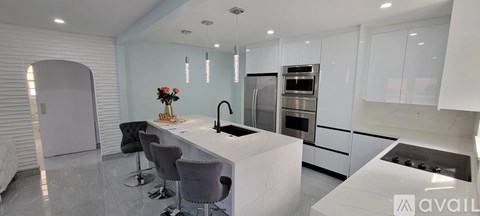 A modern kitchen with white cabinets and a central island.