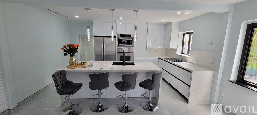 A modern kitchen with a large island and bar stools.