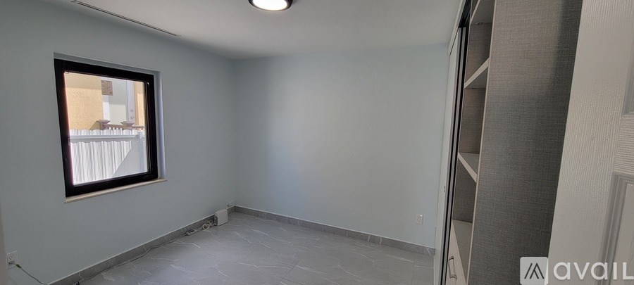 A room with a window and a wall-mounted shelf.