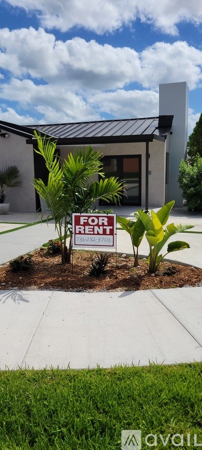 A house with a sign that says "For Rent" in front of it.