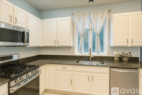 A kitchen with white cabinets and a stainless steel dishwasher.