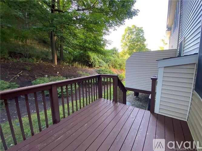 A wooden deck with a railing and trees in the background.