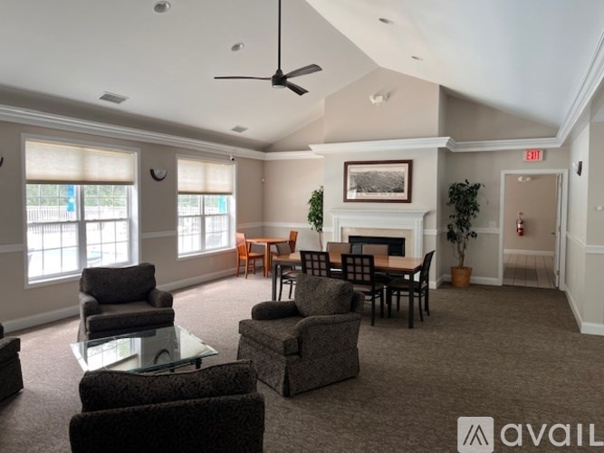 A living room with a fireplace and a ceiling fan.