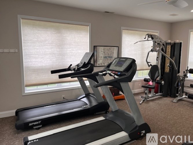 A home gym with a treadmill, elliptical trainer, and weights.