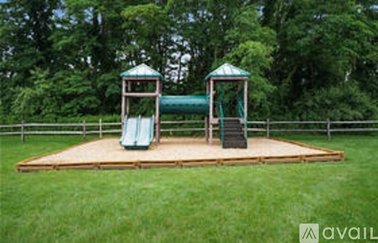 A playground with a green slide and two gazebos.