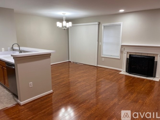 A living room with a fireplace and a kitchen area.