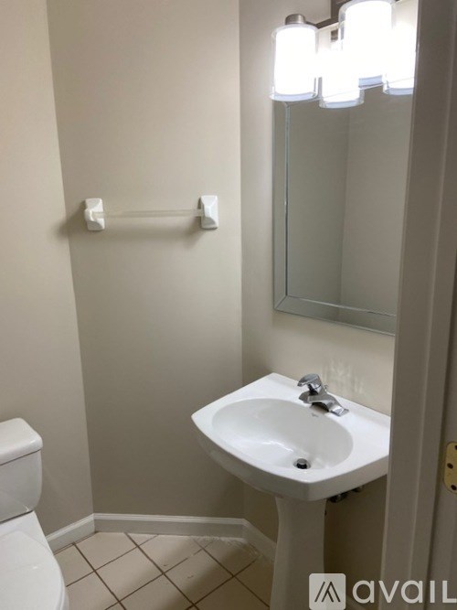 A white sink in a bathroom with a toilet and a mirror.
