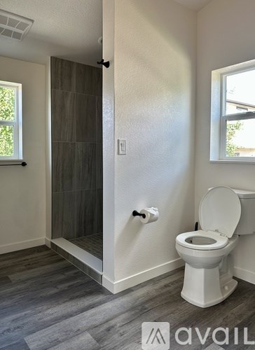 A white toilet in a bathroom with a glass door shower.