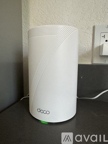 A white Decca speaker is sitting on a black surface.