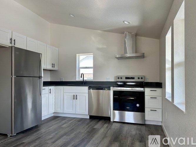 A modern kitchen with stainless steel appliances and white cabinets.