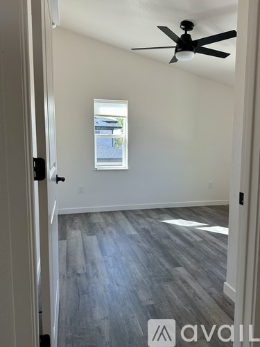 A room with a ceiling fan and a window.