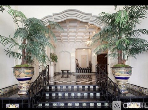 A staircase with a black railing and a tiled floor.