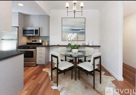 A modern kitchen with a dining table set for two.