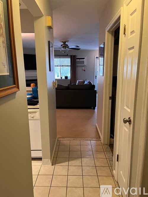 A hallway with a white door and a tiled floor.