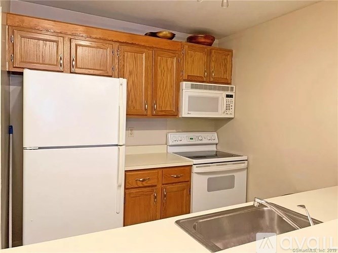 A kitchen with wooden cabinets and white appliances.