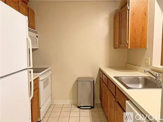 A kitchen with wooden cabinets and white appliances.