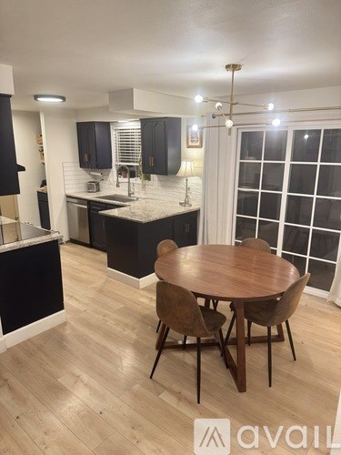 A kitchen with a table and chairs in the middle of the room.