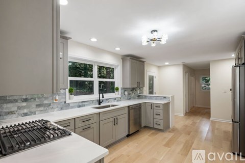 A modern kitchen with a large island and a refrigerator on the right.