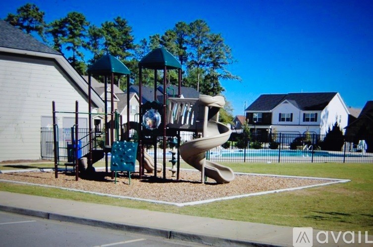 A playground with a slide and swings in a sunny day.