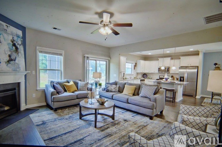 A living room with a fireplace and a rug.