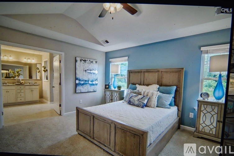 A bedroom with a large bed and a ceiling fan.