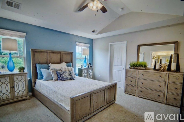 A bedroom with a bed, dresser, and mirror.