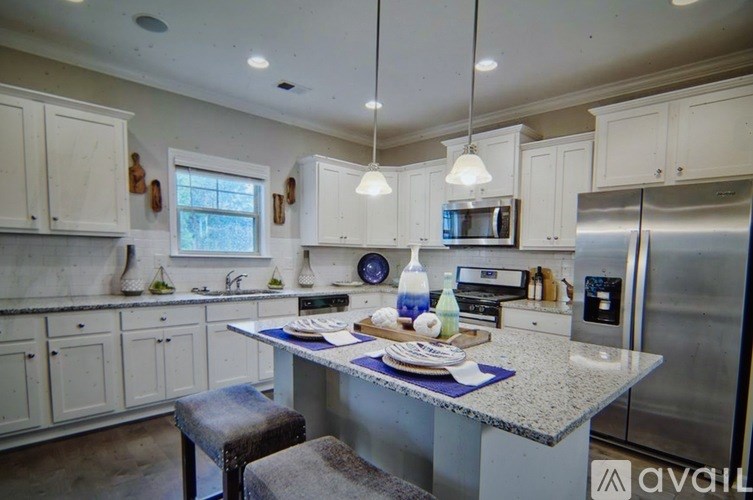A kitchen with a table and chairs in front of a refrigerator.