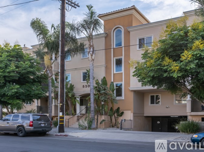 A beige building with a grey car parked in front of it.