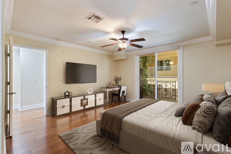A bedroom with a large bed and a flat screen TV mounted on the wall.
