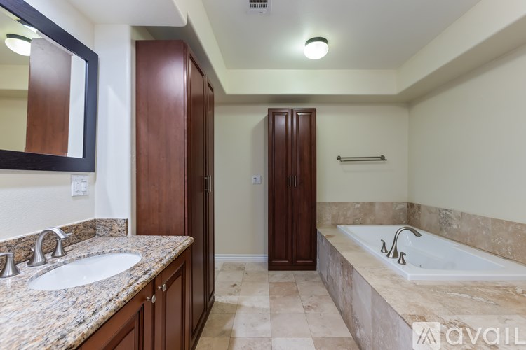 A bathroom with a marble countertop and a bathtub.