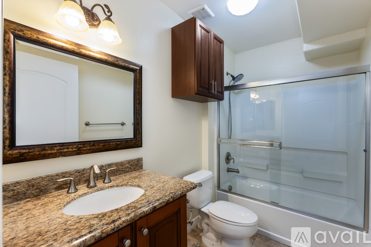 A bathroom with a sink, toilet, and shower.