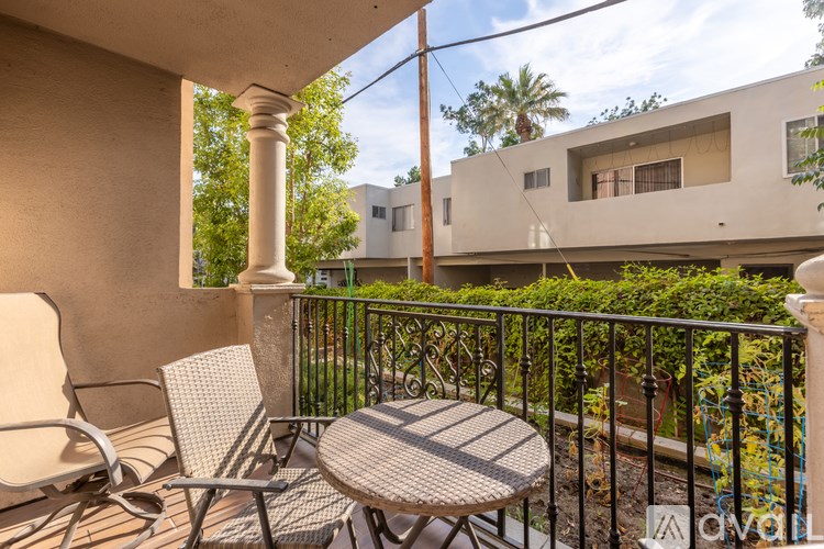 A patio with a table and chairs overlooking a street.