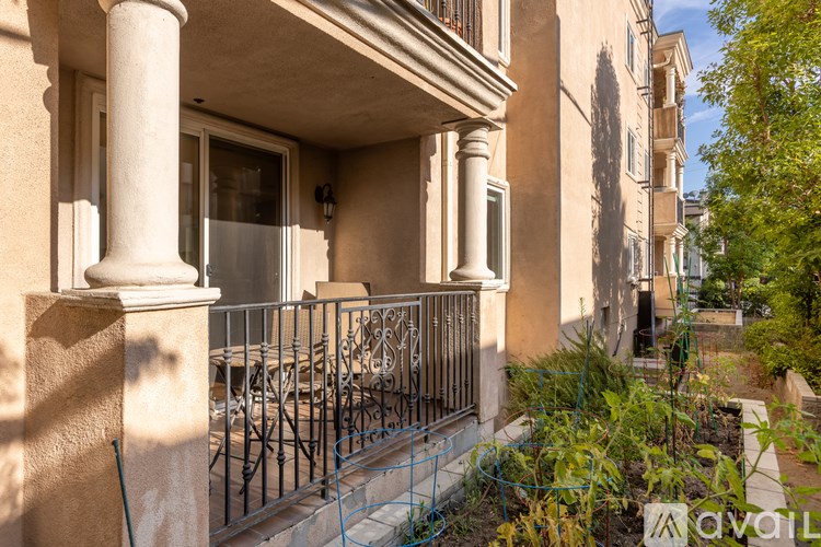 A balcony with a metal railing and a stone pillar.