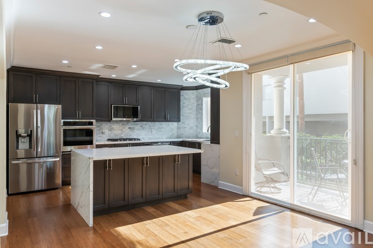 A modern kitchen with a large island and stainless steel appliances.