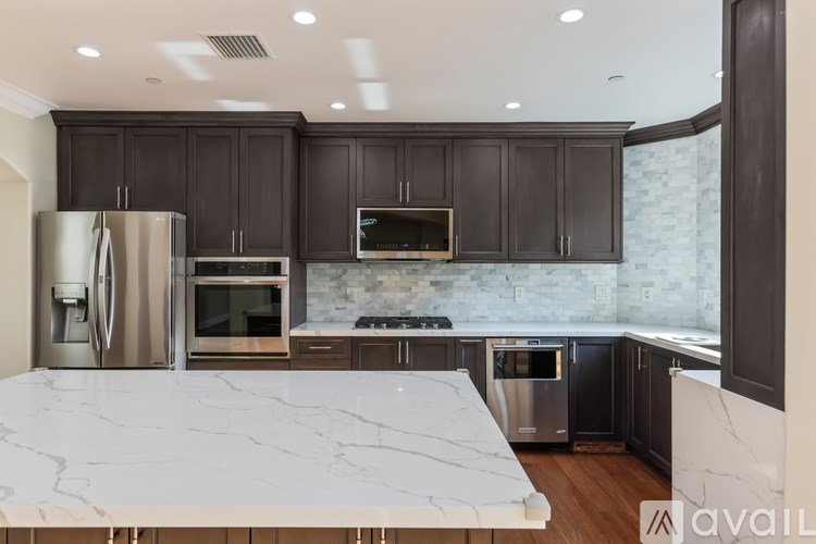 A kitchen with a marble countertop and stainless steel appliances.