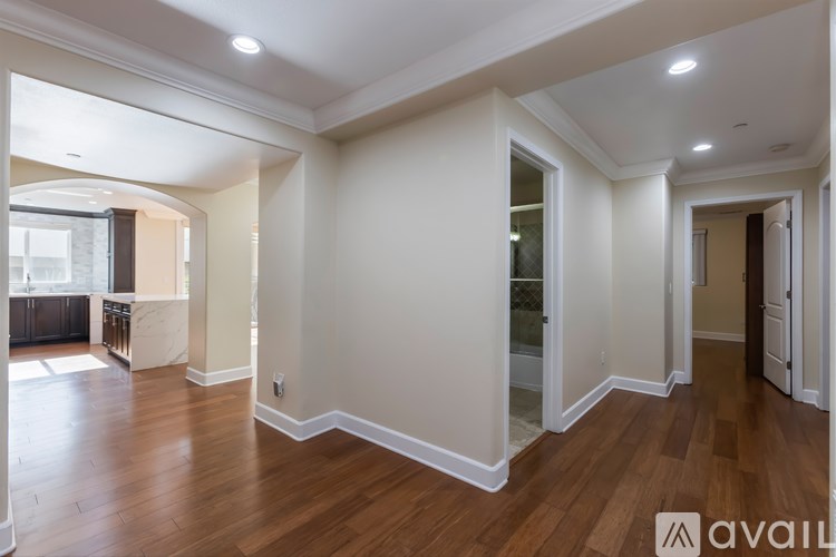 A spacious room with wooden floors and white walls.
