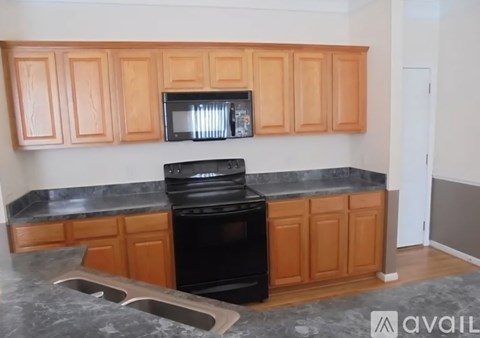 A kitchen with wooden cabinets and a black oven.