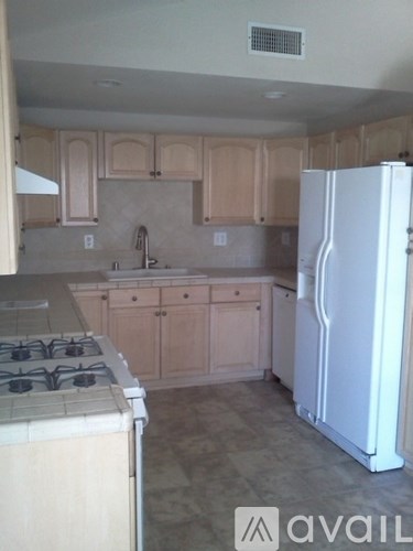 A kitchen with a white fridge and a white stove top.
