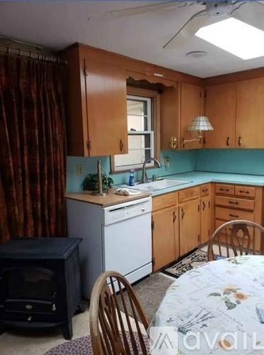 A kitchen with wooden cabinets and a blue backsplash.