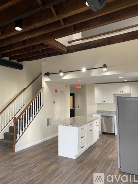 A kitchen with a refrigerator, stove, and cabinets.