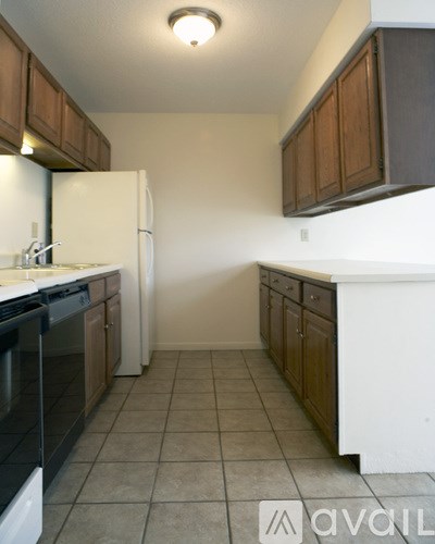 A kitchen with brown cabinets and a white fridge.