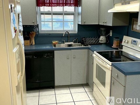 A kitchen with black appliances and white cabinets.