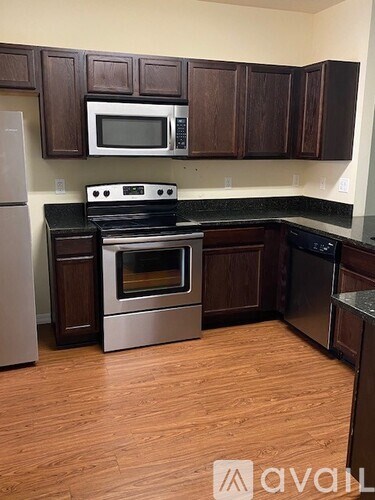A kitchen with wooden cabinets and a stainless steel oven.