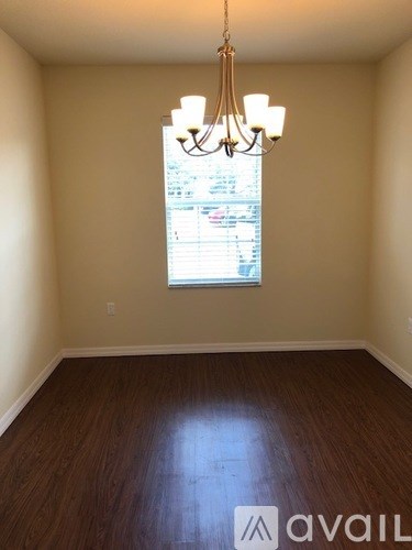 A room with a chandelier and a window.
