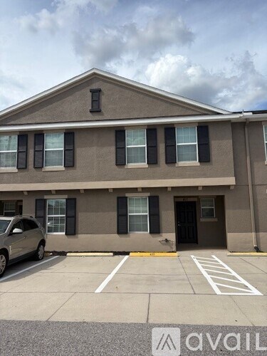 A grey building with a car parked in front.