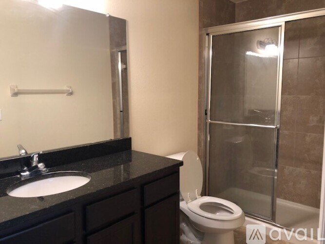 A bathroom with a sink, toilet, and shower.