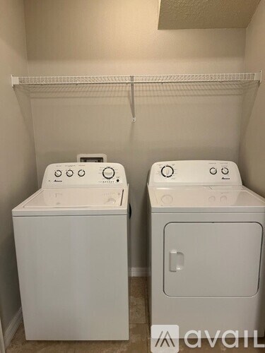 Two white front loading washing machines in a laundry room.