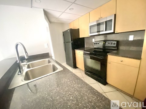 A kitchen with a black oven and a sink with a faucet.
