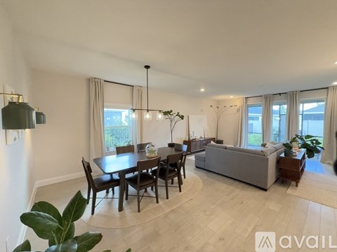 A modern living room with a dining table and chairs.