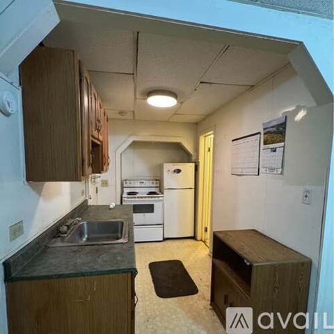 A kitchen with a sink, stove, and refrigerator.